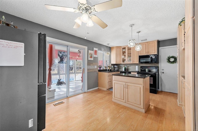 kitchen featuring visible vents, black appliances, light brown cabinets, and light wood-style flooring