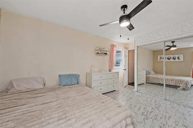 bedroom featuring ceiling fan, a closet, and a textured ceiling