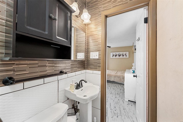 bathroom with toilet and tile walls