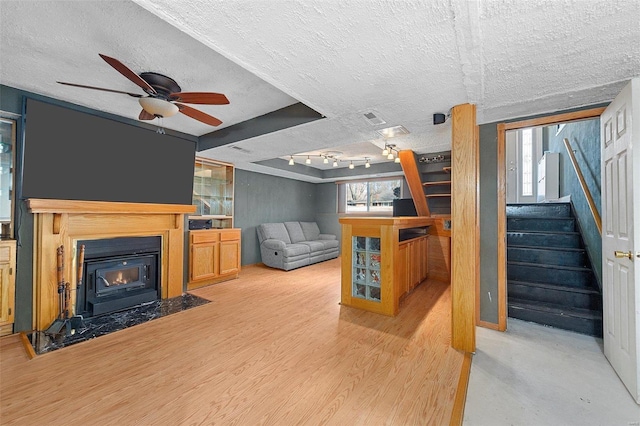 living room featuring visible vents, stairway, a ceiling fan, a textured ceiling, and wood finished floors