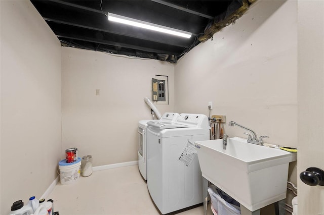 clothes washing area with a sink, laundry area, electric panel, independent washer and dryer, and baseboards