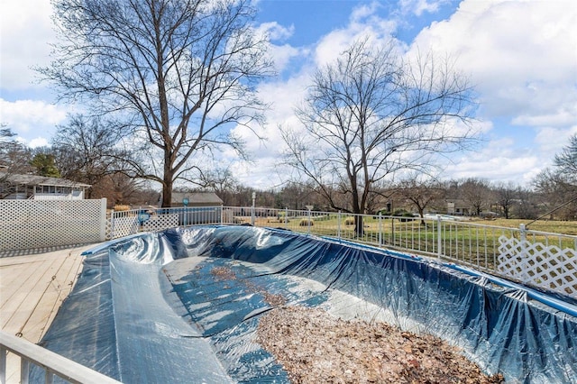 view of swimming pool featuring a wooden deck, fence, and a fenced in pool