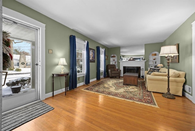 living room with light hardwood / wood-style floors and built in features