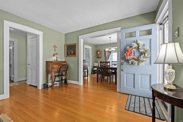 foyer entrance featuring light hardwood / wood-style flooring and a chandelier