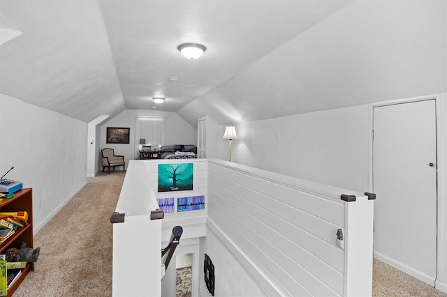 exercise room with light carpet and vaulted ceiling