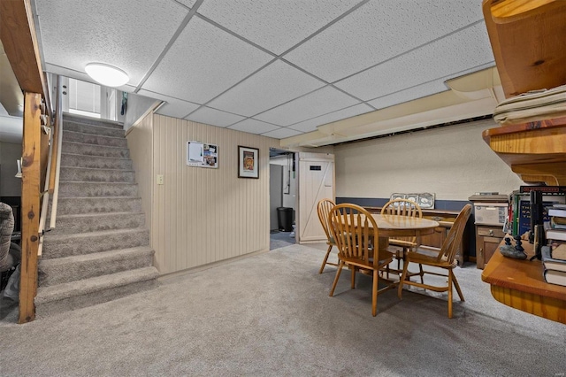 carpeted dining room featuring a drop ceiling