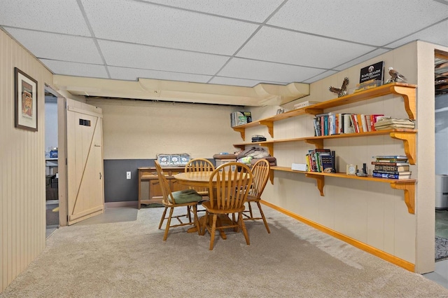 carpeted dining area featuring a drop ceiling