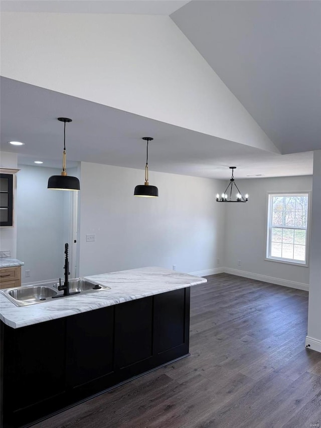 kitchen with lofted ceiling, baseboards, dark wood-type flooring, and a sink