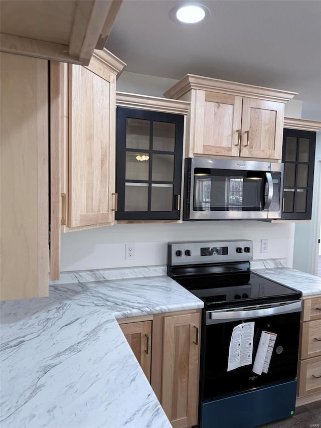 kitchen with stainless steel appliances, glass insert cabinets, light stone counters, and light brown cabinetry