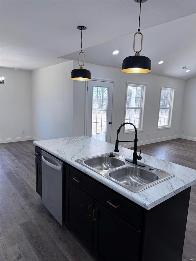 kitchen with dishwasher, dark cabinetry, open floor plan, and a sink