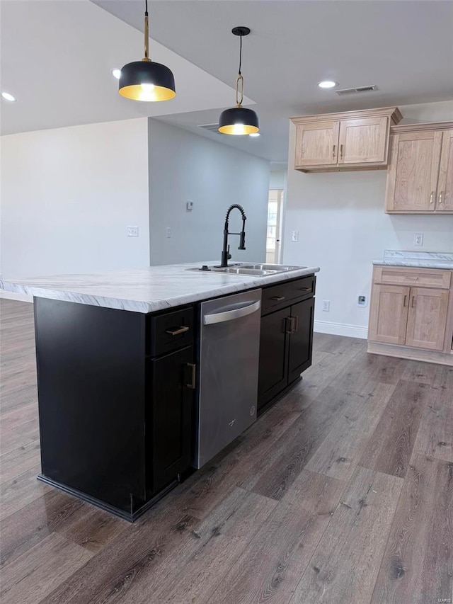 kitchen featuring light countertops, stainless steel dishwasher, a kitchen island with sink, a sink, and wood finished floors