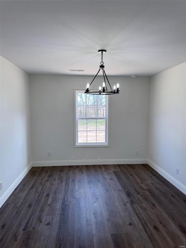 unfurnished dining area featuring dark wood-style floors, visible vents, a notable chandelier, and baseboards