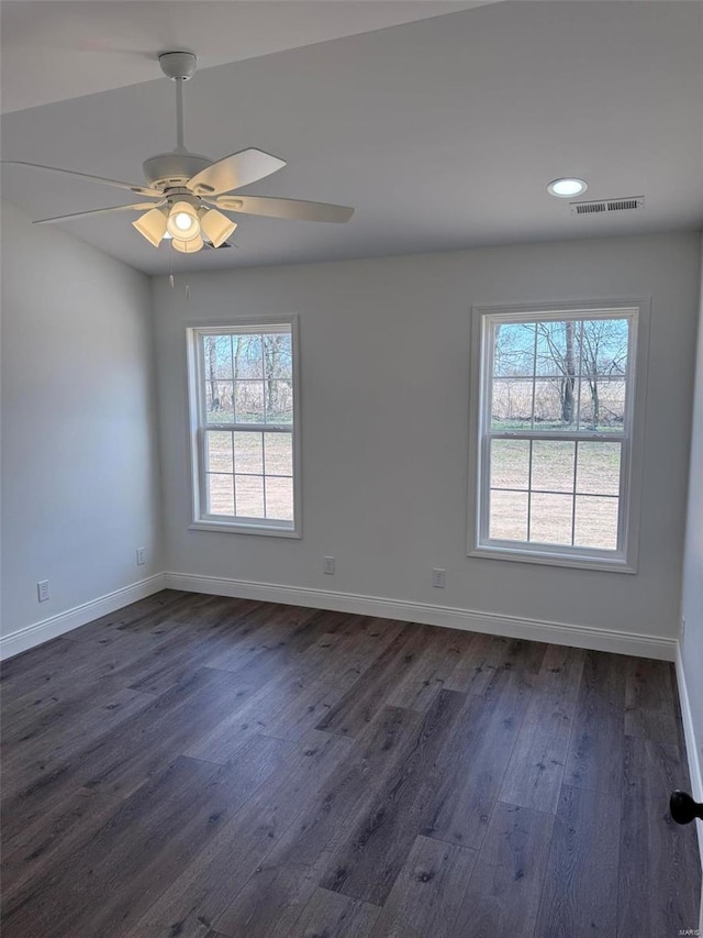 unfurnished room with dark wood-style floors, baseboards, visible vents, and recessed lighting