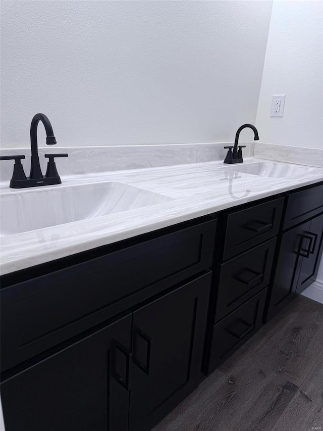 bathroom featuring double vanity, a sink, and wood finished floors