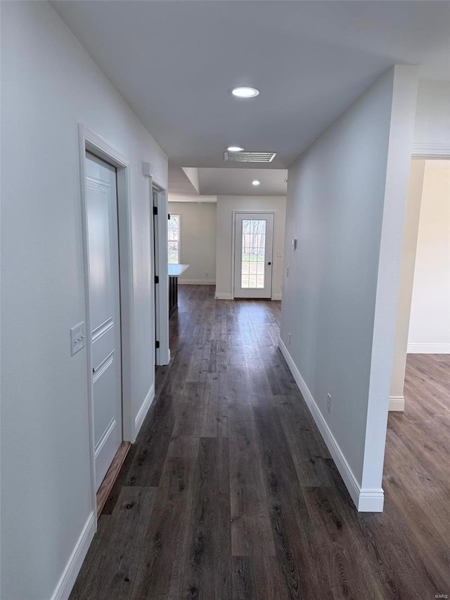 hallway with baseboards, dark wood-style flooring, and recessed lighting