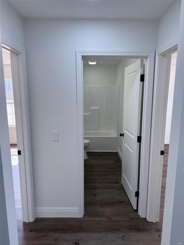 hallway with dark wood-style floors and baseboards