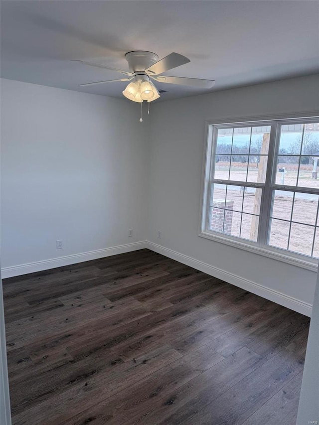 unfurnished room featuring dark wood-style floors, ceiling fan, and baseboards