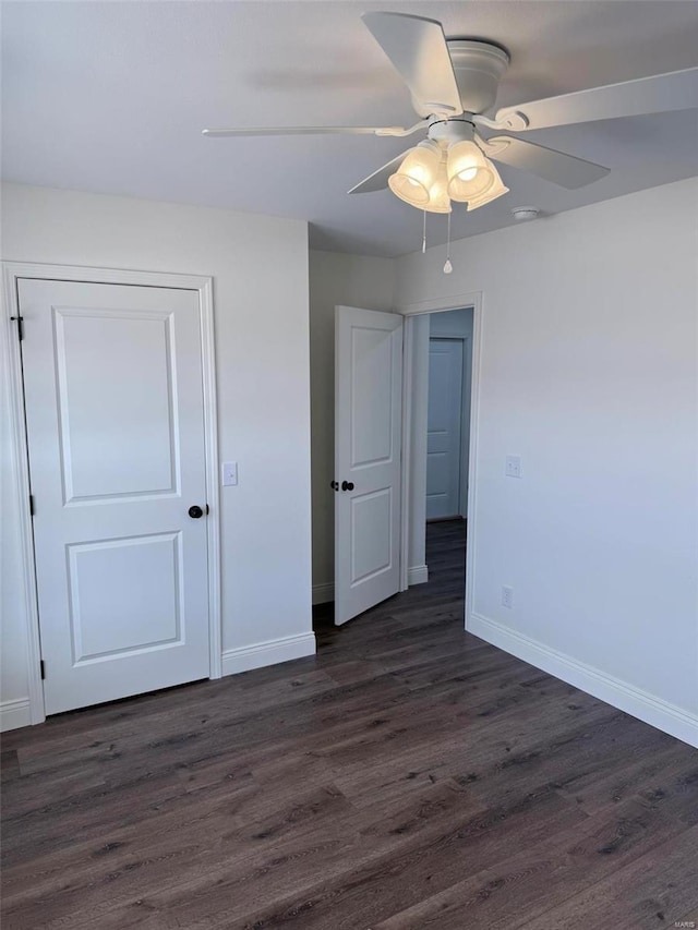 unfurnished bedroom with dark wood-style floors, ceiling fan, and baseboards