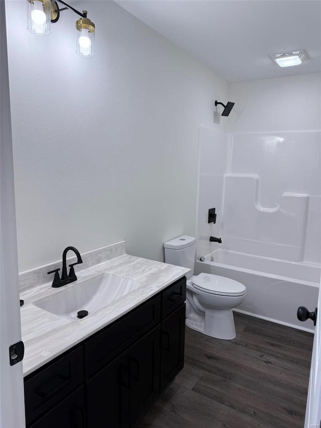 full bathroom with toilet, shower / bathing tub combination, wood finished floors, and vanity