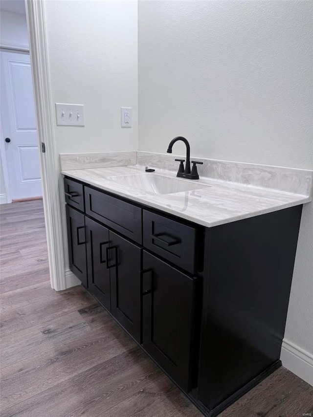 bathroom featuring vanity, baseboards, and wood finished floors