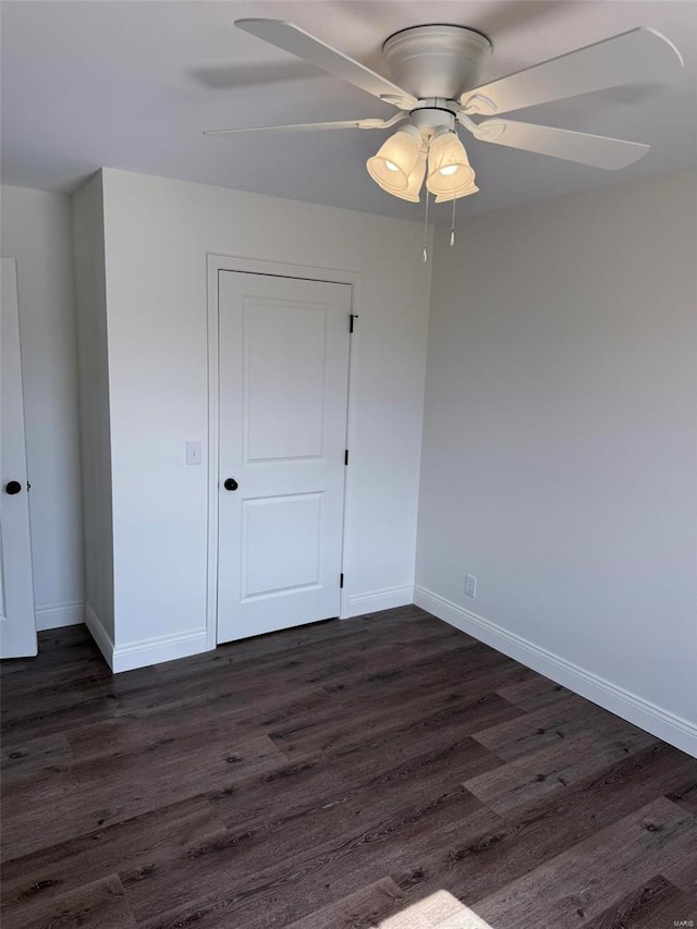 unfurnished bedroom featuring dark wood-style floors, ceiling fan, and baseboards