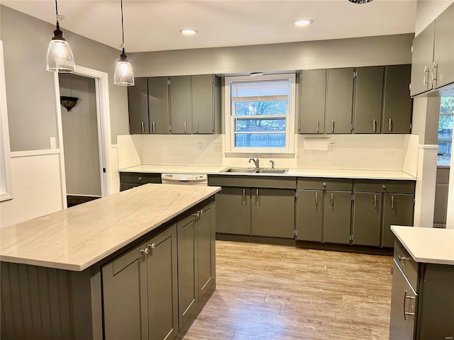 kitchen featuring hanging light fixtures, light hardwood / wood-style floors, plenty of natural light, and sink