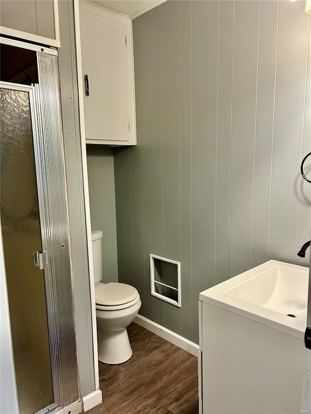 bathroom featuring wooden walls, wood-type flooring, and toilet