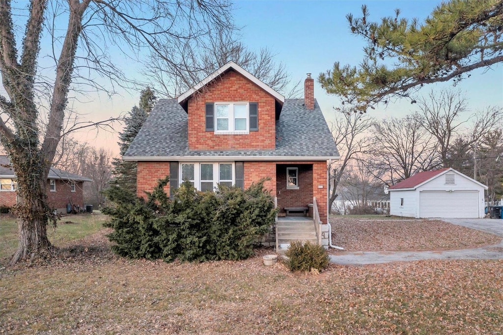 view of front of home with a lawn, a garage, and an outbuilding