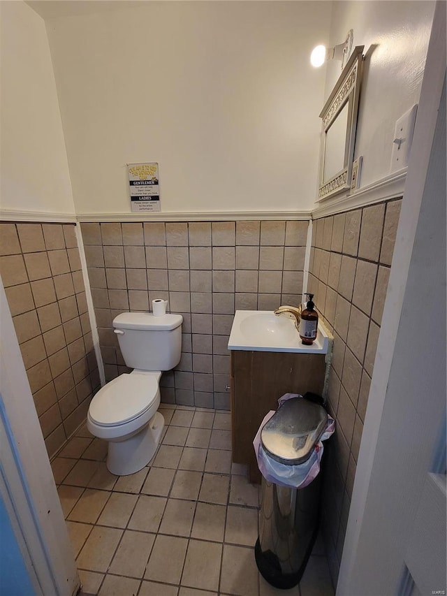 bathroom featuring tile patterned flooring, vanity, toilet, and tile walls