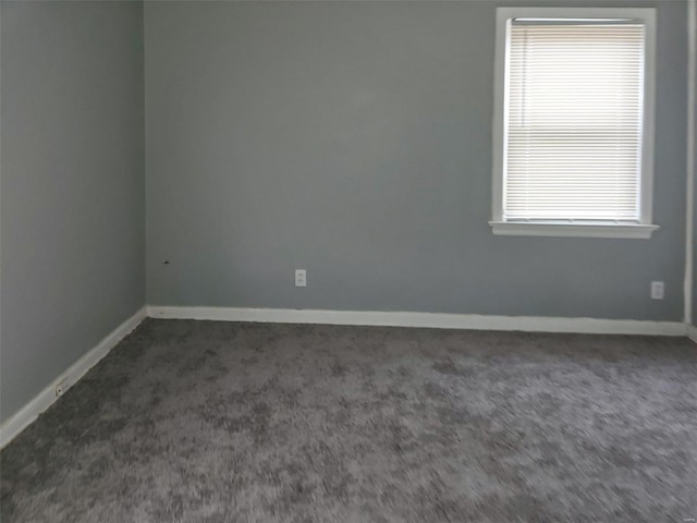 spare room featuring dark carpet