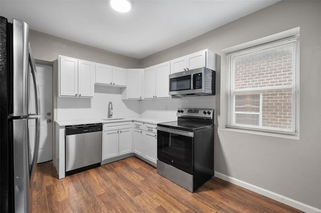 kitchen with stainless steel appliances, white cabinetry, dark wood-type flooring, and sink