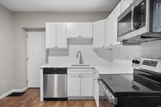 kitchen featuring white cabinets, sink, decorative backsplash, appliances with stainless steel finishes, and dark hardwood / wood-style flooring