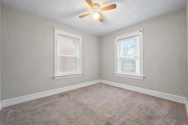 empty room with carpet, ceiling fan, and a textured ceiling