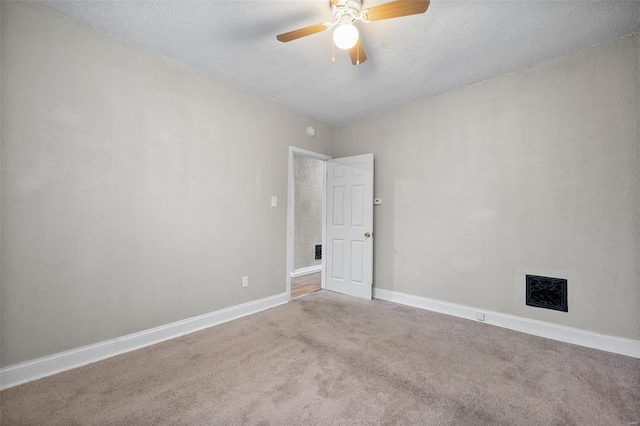 carpeted spare room featuring ceiling fan and a textured ceiling