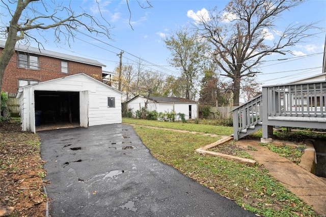 exterior space with a garage, an outdoor structure, and a wooden deck