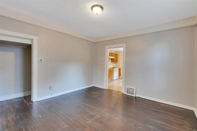 unfurnished room featuring a textured ceiling and dark wood-type flooring