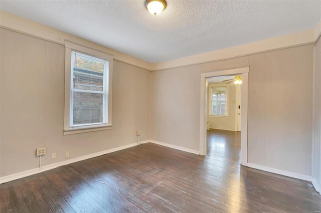 unfurnished room featuring a textured ceiling, dark hardwood / wood-style flooring, and ceiling fan