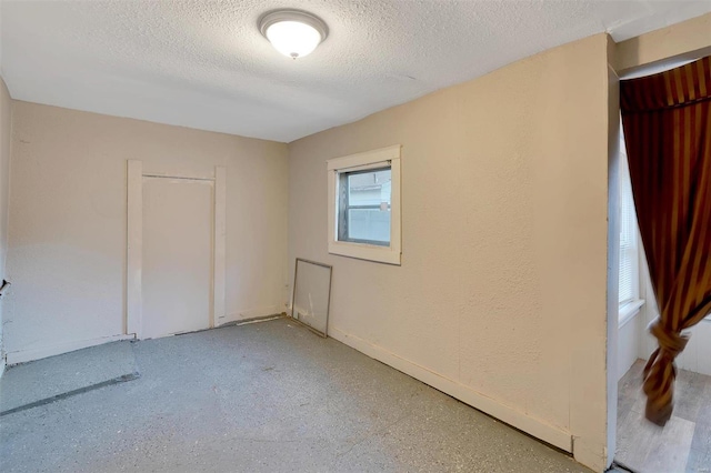 unfurnished room featuring a textured ceiling and a wealth of natural light