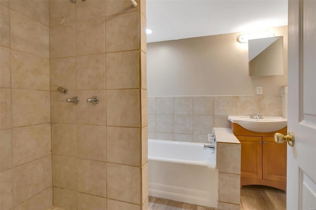 bathroom with vanity, separate shower and tub, wood-type flooring, and tile walls