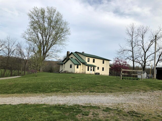 view of side of home with a yard