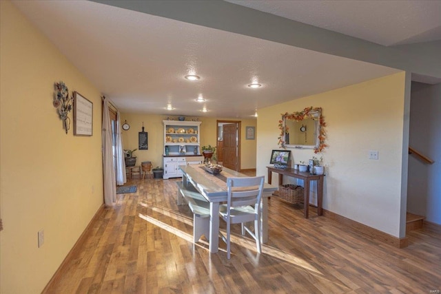 dining space with hardwood / wood-style flooring and a textured ceiling