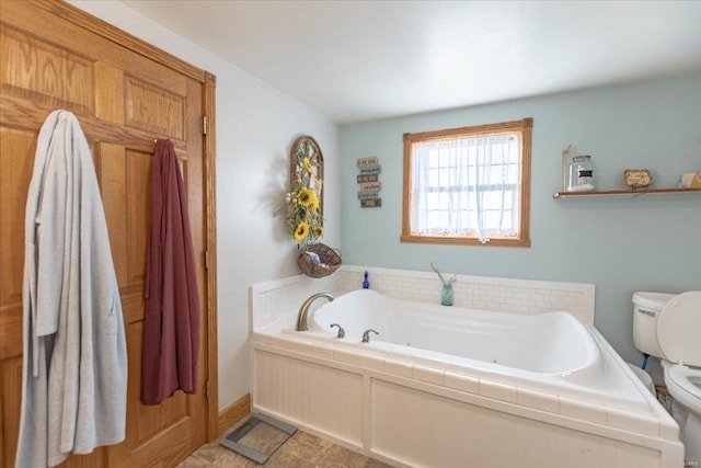 bathroom featuring toilet and a tub to relax in