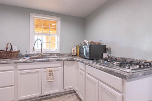 kitchen with sink, white cabinetry, and stainless steel gas stovetop