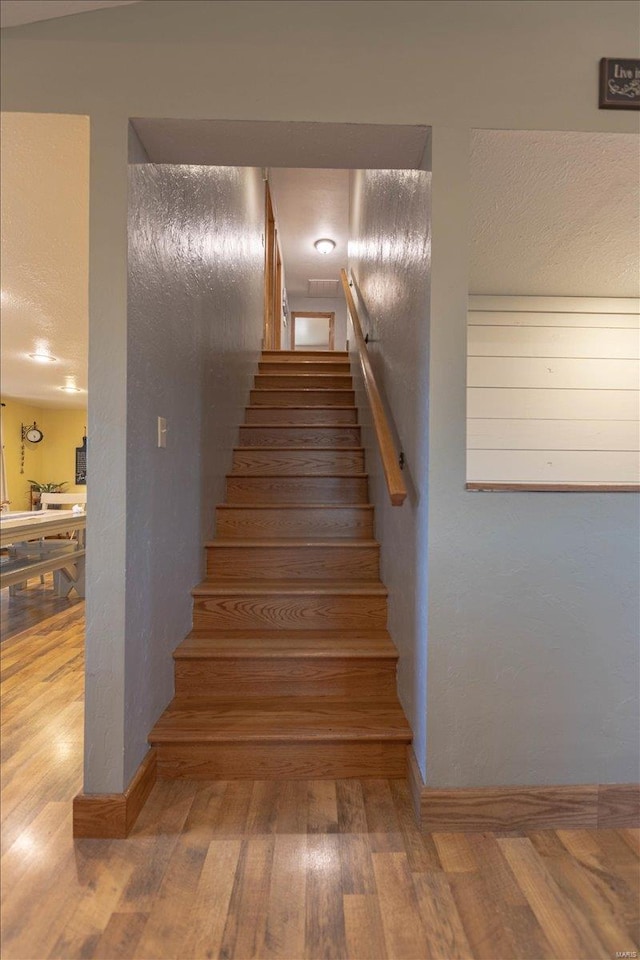 stairs with hardwood / wood-style floors