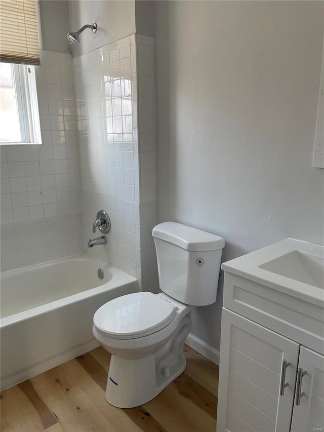 full bathroom featuring vanity, toilet, tiled shower / bath, and hardwood / wood-style flooring