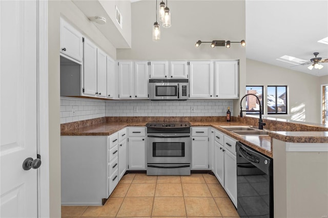 kitchen with vaulted ceiling with skylight, tasteful backsplash, white cabinetry, sink, and stainless steel appliances