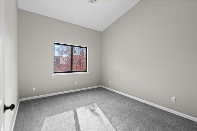 unfurnished room featuring lofted ceiling and carpet flooring