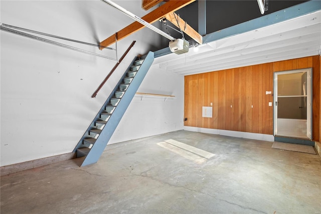 garage featuring a garage door opener and wood walls