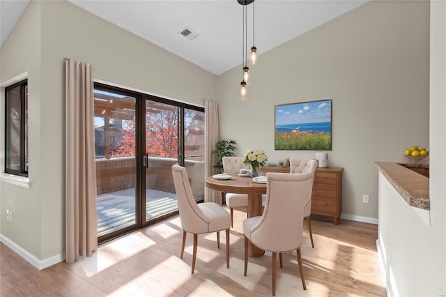 dining room with lofted ceiling and light hardwood / wood-style floors