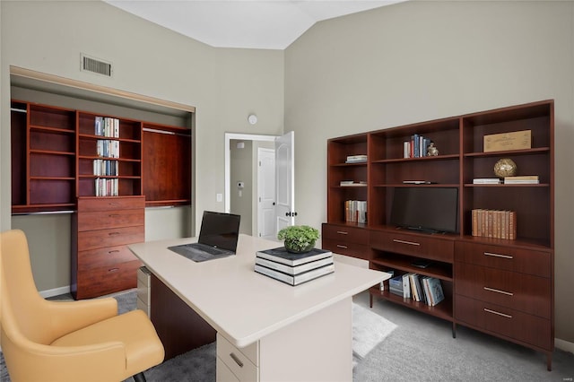 carpeted office space with vaulted ceiling